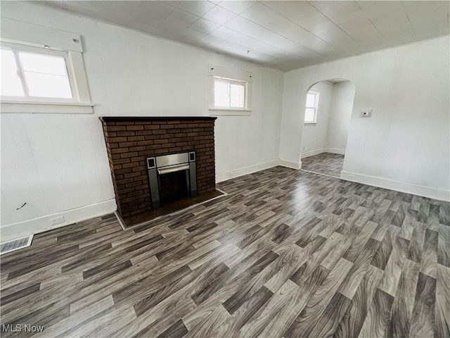 unfurnished living room featuring a fireplace and dark wood-type flooring