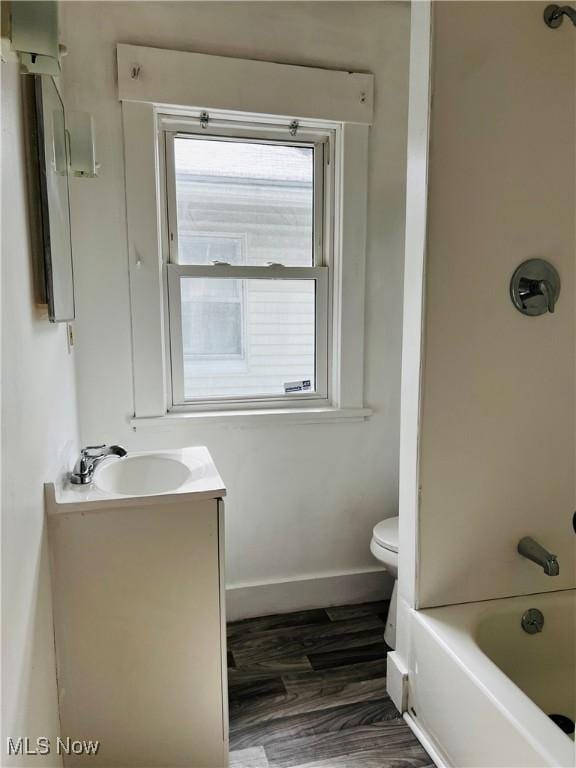 full bathroom featuring  shower combination, toilet, vanity, and hardwood / wood-style flooring