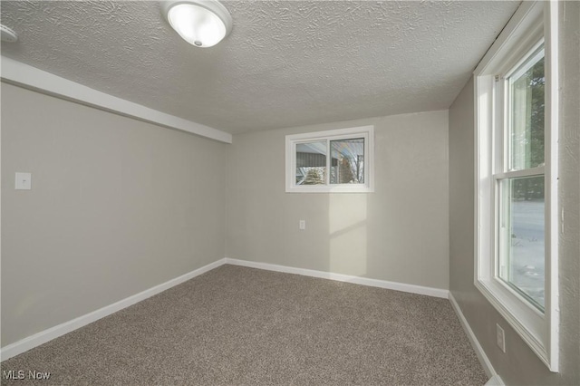 carpeted empty room with a textured ceiling