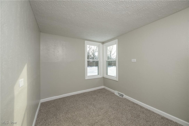 unfurnished room featuring a textured ceiling and carpet floors