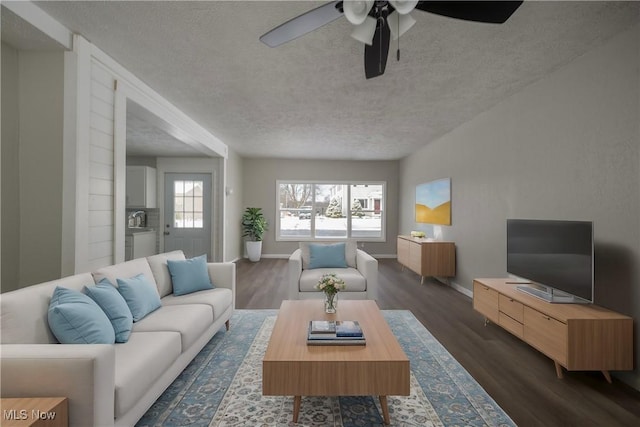 living room with a textured ceiling, ceiling fan, and dark hardwood / wood-style floors