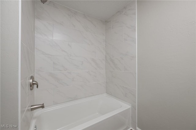 bathroom featuring tiled shower / bath