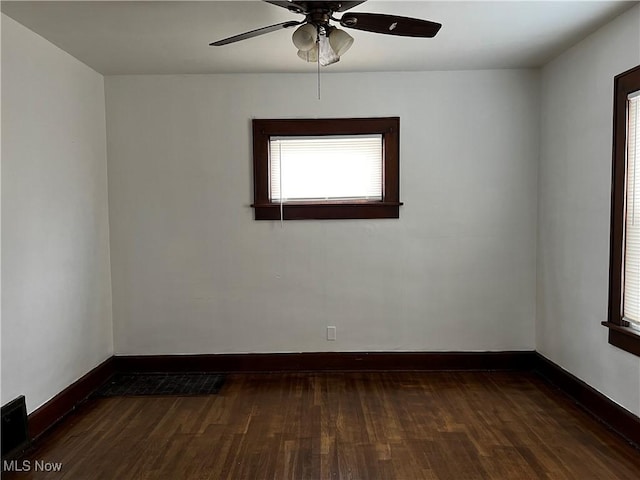 empty room with ceiling fan and dark hardwood / wood-style flooring