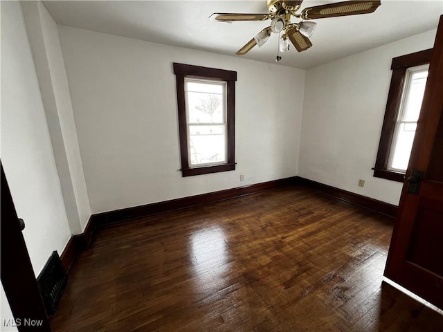 spare room featuring dark wood-type flooring and ceiling fan