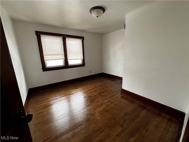 unfurnished room featuring dark wood-type flooring