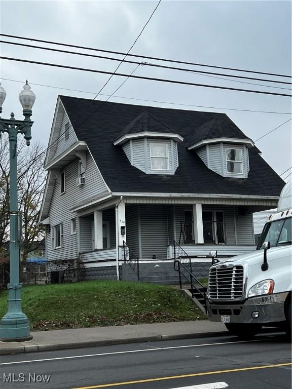 view of front of property with a porch and a front yard