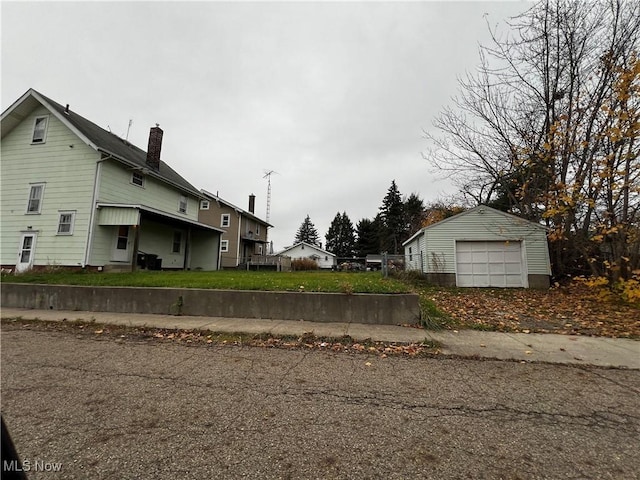 view of side of home featuring a yard, a garage, and an outdoor structure