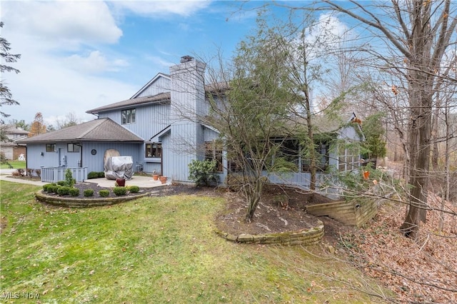 rear view of house featuring a yard and a patio area