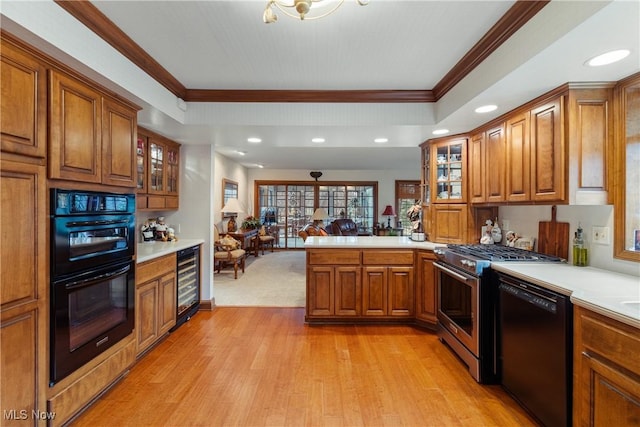 kitchen with black appliances, crown molding, kitchen peninsula, and wine cooler