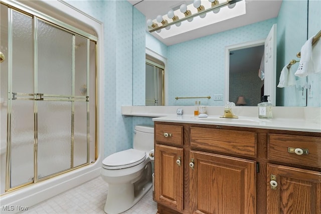 bathroom with vanity, a shower with shower door, and toilet