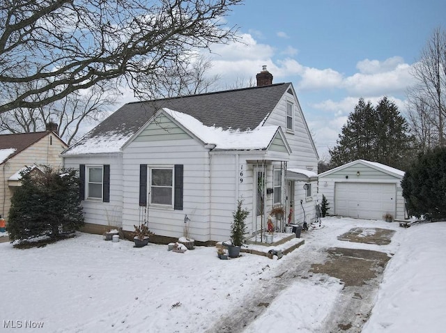 bungalow-style house featuring a garage and an outbuilding