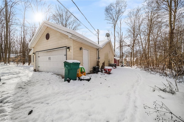 view of snowy exterior with a garage