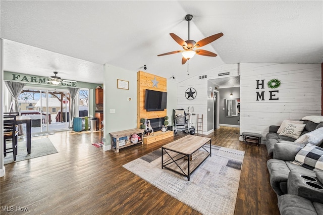 living room with visible vents, a ceiling fan, a textured ceiling, wood finished floors, and vaulted ceiling