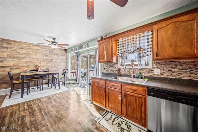 kitchen with dishwasher, dark countertops, a sink, and ceiling fan