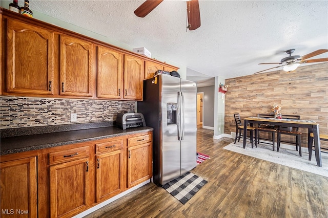 kitchen featuring dark countertops, dark wood-type flooring, ceiling fan, and stainless steel refrigerator with ice dispenser