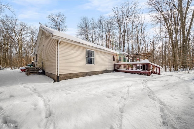 snow covered property with a deck