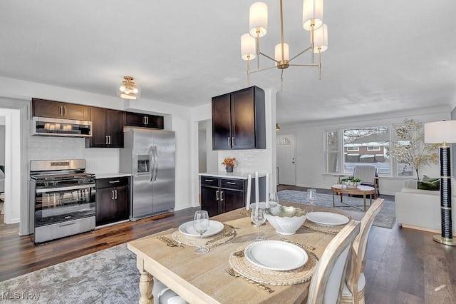 dining space featuring dark hardwood / wood-style flooring and an inviting chandelier