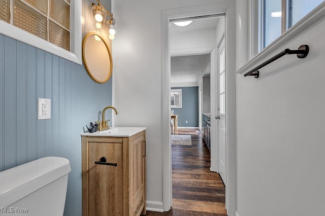 bathroom with wood-type flooring, vanity, and toilet