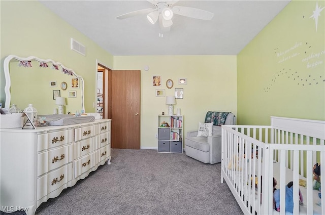 bedroom with a nursery area, carpet floors, and ceiling fan