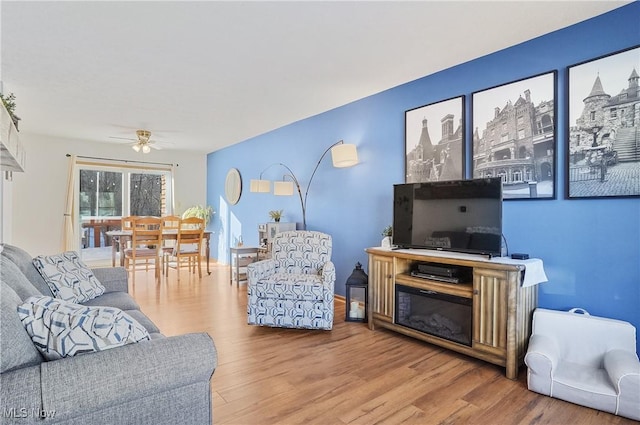 living room featuring ceiling fan and hardwood / wood-style floors