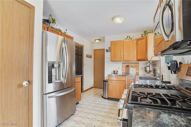 kitchen featuring appliances with stainless steel finishes and dark stone countertops