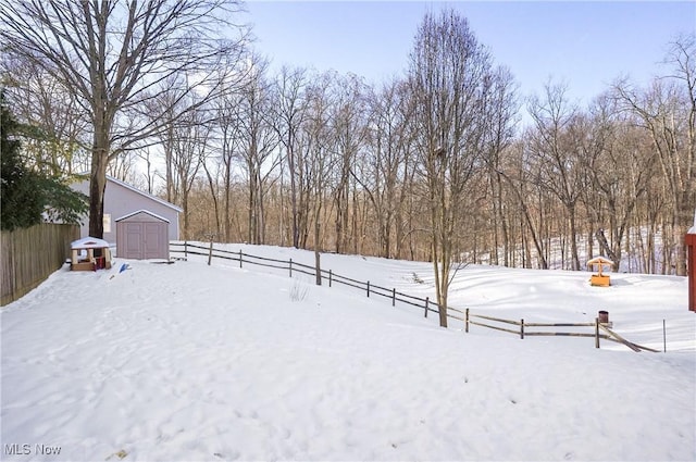 yard covered in snow featuring a storage shed