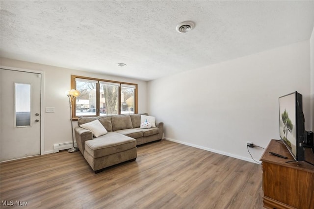 living room with wood-type flooring, a textured ceiling, and a baseboard heating unit