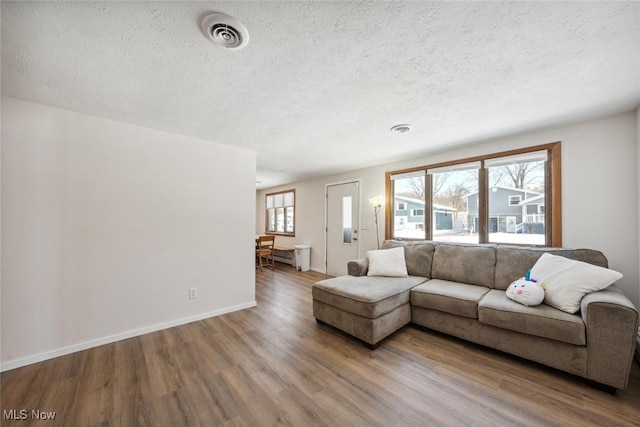 unfurnished living room featuring hardwood / wood-style flooring, a textured ceiling, and a wealth of natural light