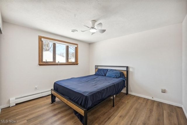 bedroom with billiards, wood-type flooring, a baseboard heating unit, and ceiling fan