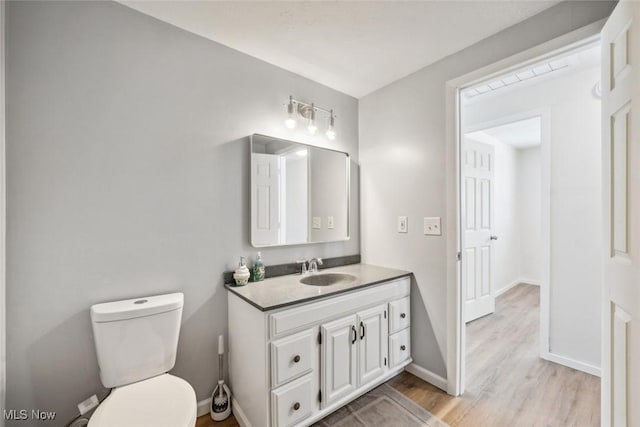 bathroom featuring hardwood / wood-style flooring, vanity, and toilet