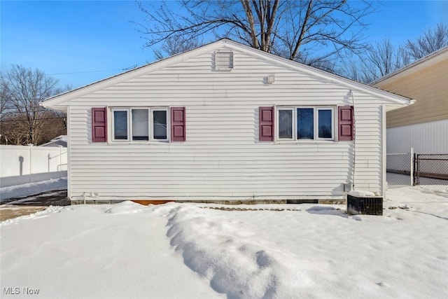 snow covered property with central AC