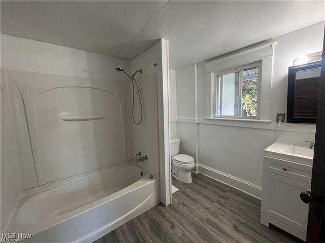 full bathroom with shower / bathing tub combination, wood-type flooring, vanity, and toilet