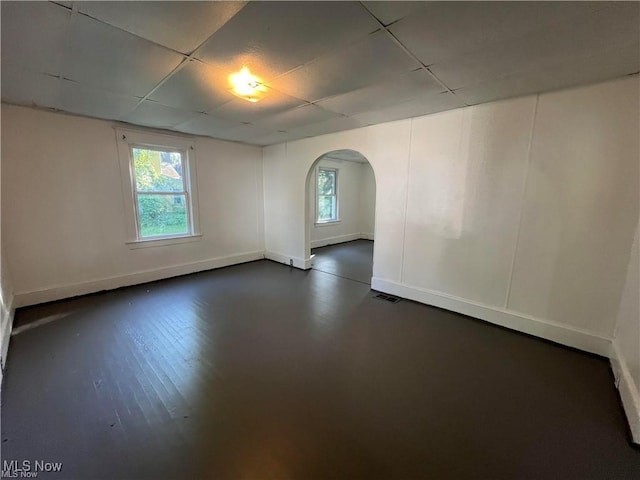 spare room featuring a paneled ceiling and a wealth of natural light