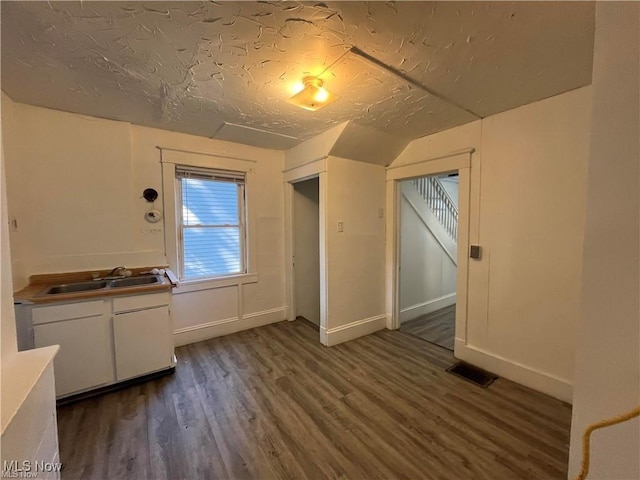 bonus room featuring sink, a textured ceiling, and dark hardwood / wood-style floors