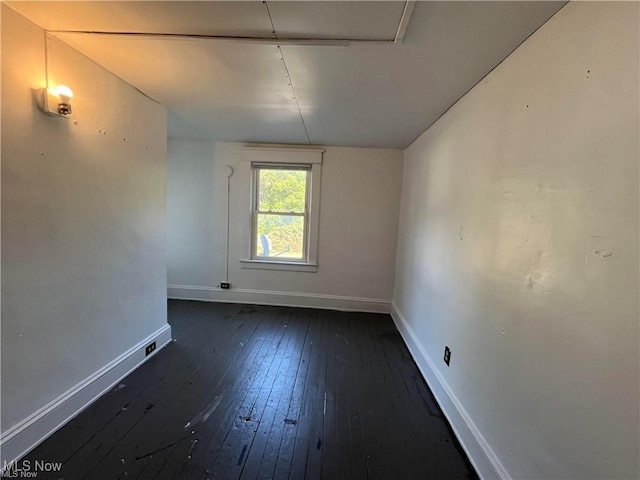 unfurnished room with dark hardwood / wood-style flooring