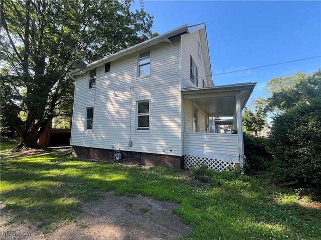 view of property exterior with a lawn and covered porch