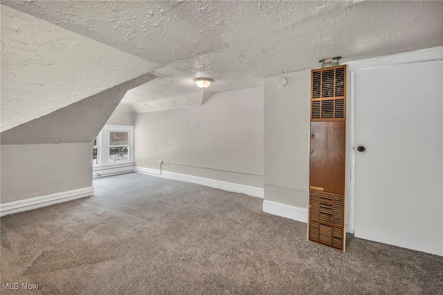 additional living space with a textured ceiling, vaulted ceiling, and carpet flooring