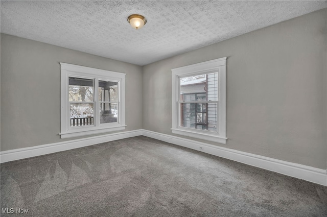 empty room with a textured ceiling and carpet floors