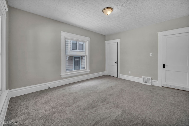 carpeted spare room featuring a textured ceiling