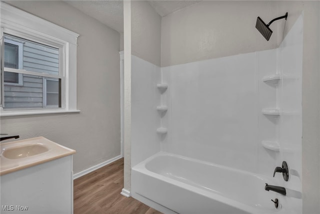 bathroom with wood-type flooring, vanity, plenty of natural light, a textured ceiling, and shower / bathing tub combination