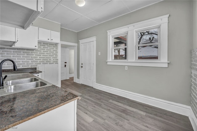 kitchen with white cabinets, light hardwood / wood-style flooring, and sink