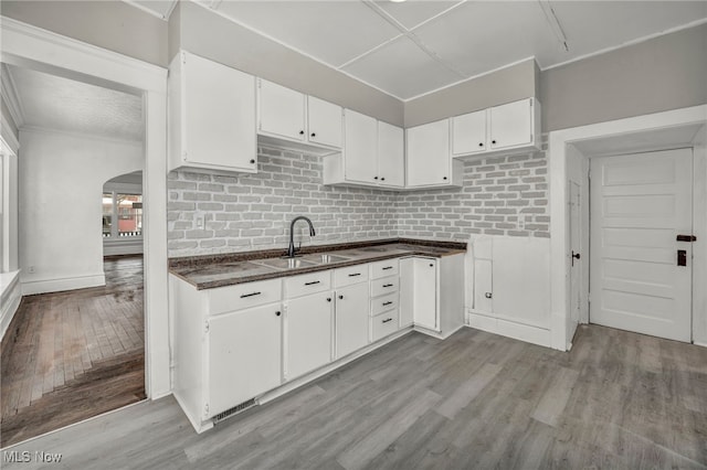 kitchen with sink, white cabinetry, and light wood-type flooring