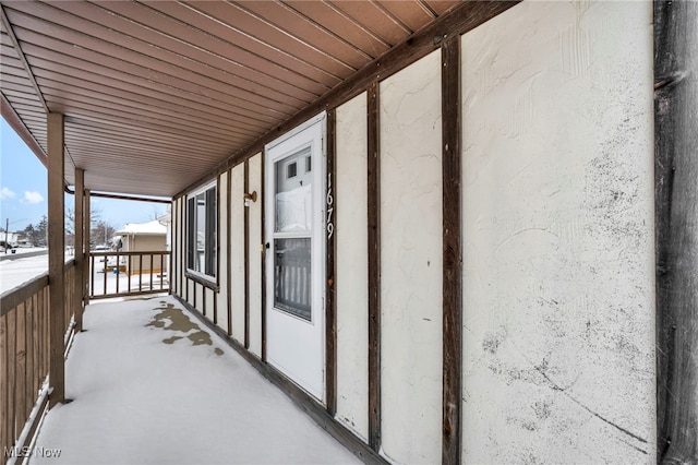 view of snow covered back of property