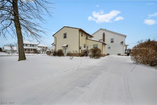 view of snow covered back of property