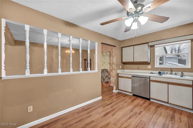 kitchen featuring stainless steel dishwasher, light hardwood / wood-style flooring, ceiling fan with notable chandelier, white cabinets, and sink