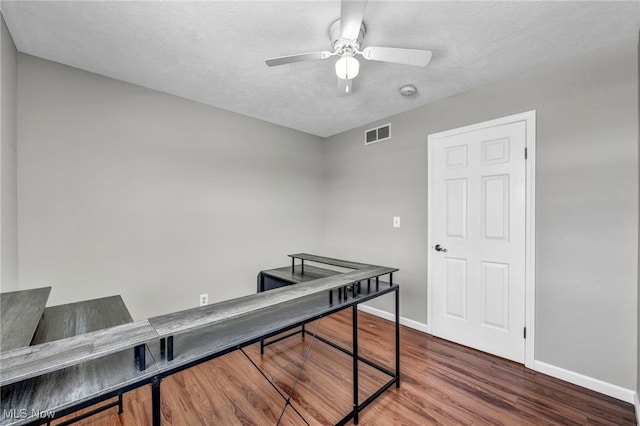 office space with ceiling fan, hardwood / wood-style floors, and a textured ceiling