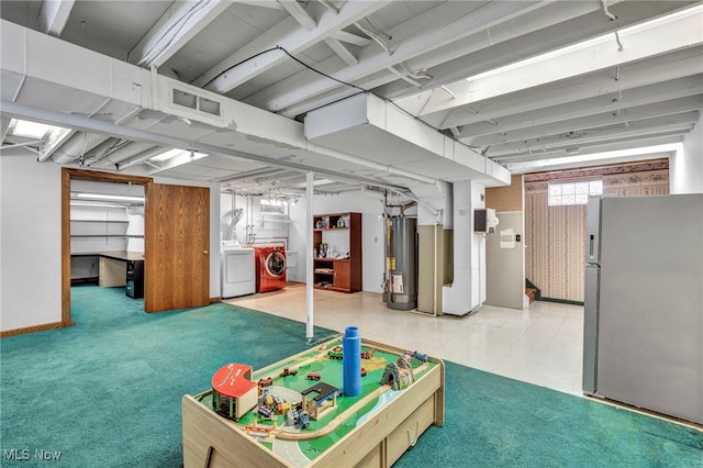 basement with stainless steel refrigerator, separate washer and dryer, water heater, and carpet