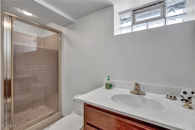 bathroom with toilet, vanity, and walk in shower