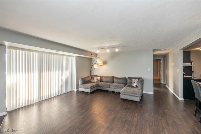 living room featuring a textured ceiling and dark hardwood / wood-style floors