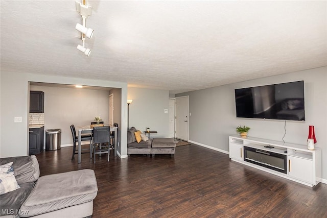 living room with a textured ceiling and dark hardwood / wood-style flooring